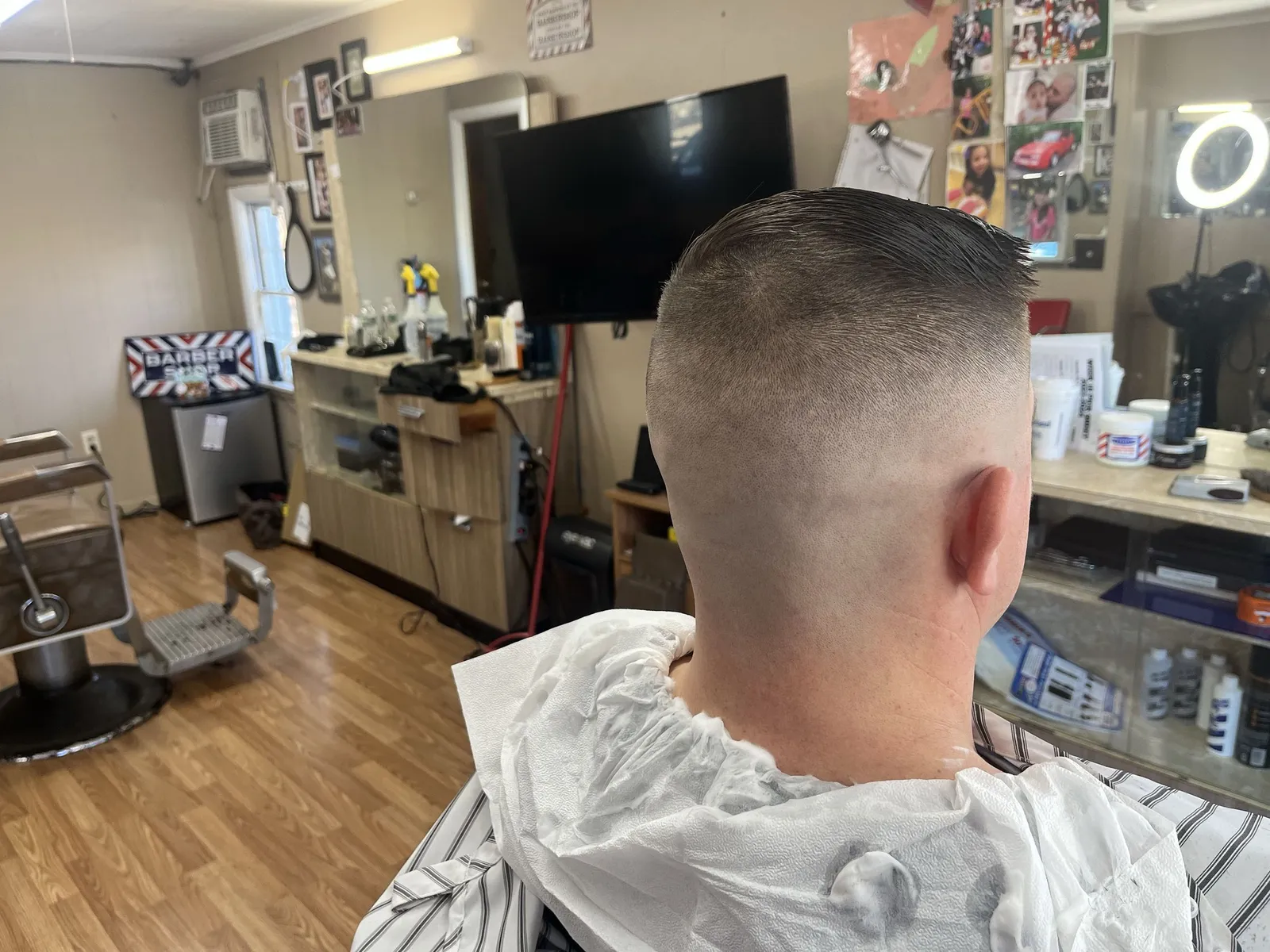 Back and side of a man's head with a high skin fade and a slicked top
